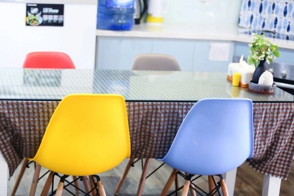 Bộ bàn ăn được đặt ngay cạnh bếp nấu. Mặt bàn kính kết hợp với những chiếc ghế nhiều màu sắc mang đến góc sum vầy mỗi tối của gia đình thêm vui nhộn, ấm cúng.